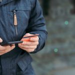 Pessoa usa um smartphone para inserir dados de cartão durante uma compra online.